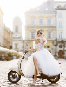 sposa-in-abito-da-sposa-e-occhiali-da-sole-in-posa-su-scooter